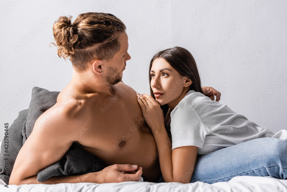 Pretty woman looking at muscular boyfriend on bed Pretty woman looking at muscular boyfriend on bed