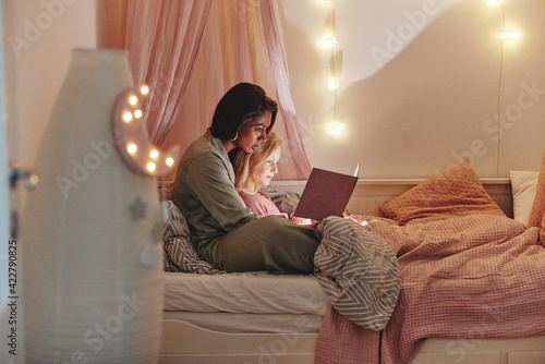 Fotografie Mom reading a bedtime story to her daughter