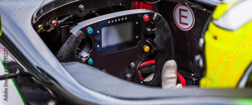 A driver holds the steering wheel of his supercar © danieleorsi