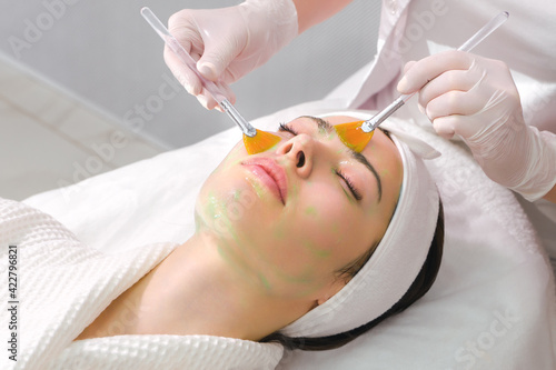 Facial skin care. A mask is applied to a woman face in a cosmetology clinic. Close up