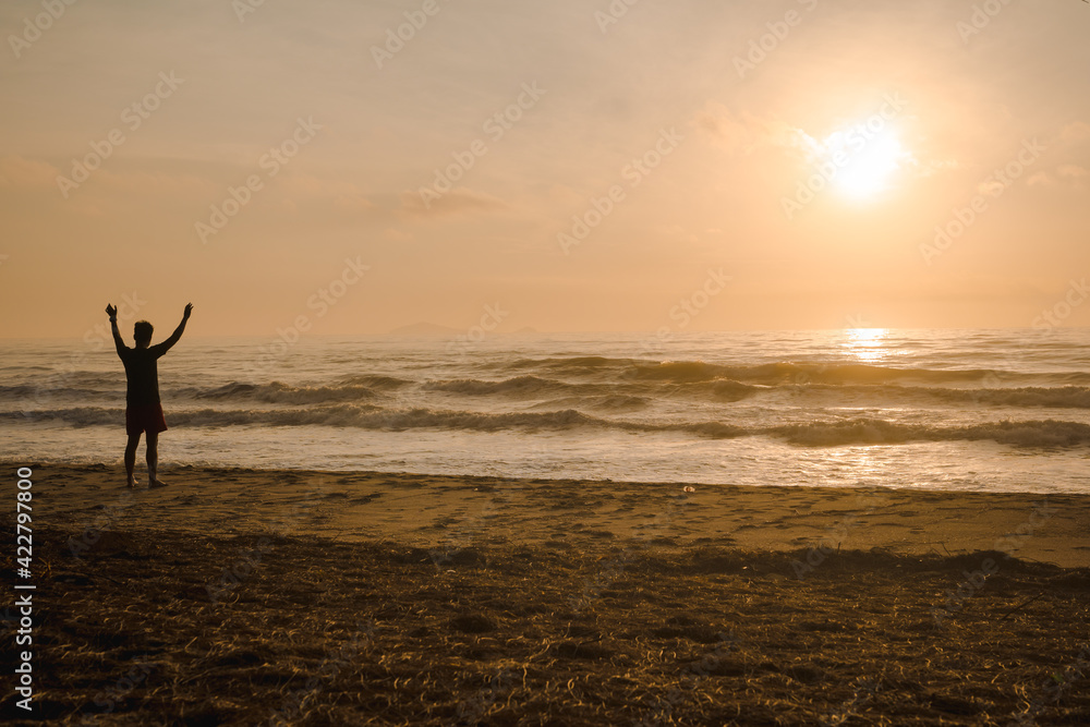 silhouette man run on beach with sunrise and sea background