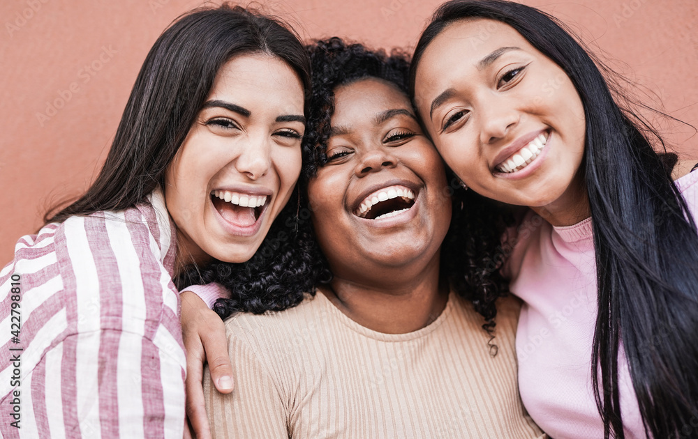 Happy latin women laughing and looking in camera - Millennial girls having  fun outdoor taking a selfie Stock Photo
