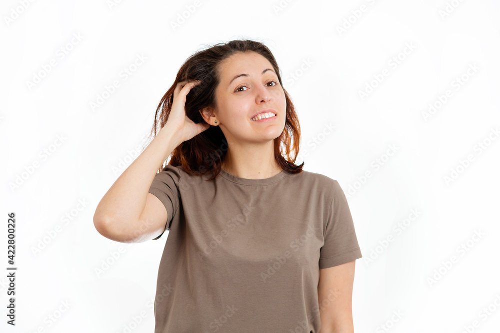 A young Caucasian woman is scratching her hair from dandruff and irritation. White background. The concept of hair care A young Caucasian woman is scratching her hair from dandruff and irritation. White background. The concept of hair care