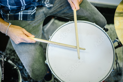 Close up of a man playing drums in a recording studio, top view.