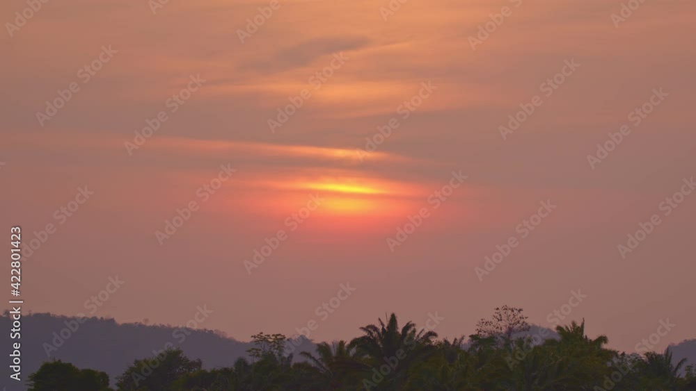 .Beautiful red sky in the sunrise over forested mountains..The red sun rose above the mountain peak, slowly rising until the sun turned yellow. .Beautiful red sky in the sunrise over forested mountains..The red sun rose above the mountain peak, slowly rising until the sun turned yellow.