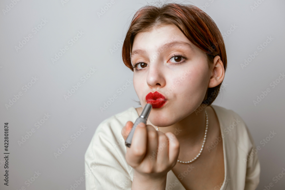 women paint their lips with red lipstick. Light background women paint their lips with red lipstick. Light background