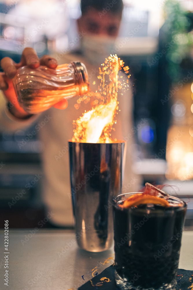 Fototapeta Bartender generating a flame while creating a cocktail