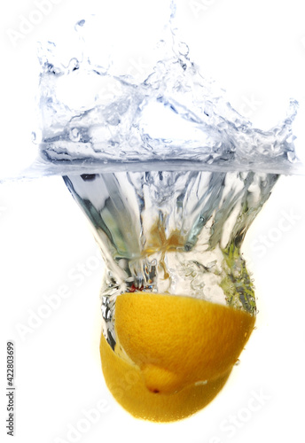 Obraz na płótnie bright yellow lemons dropped in clear water w salonie