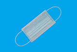 White disposable medical mask on a blue background. Protection against infection. Personal hygiene. Free space for insertion.