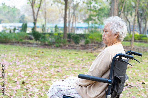 Asian senior or elderly old lady woman patient pain her knee on wheelchair in park, healthy strong medical concept. © amazing studio