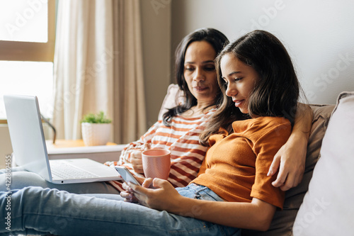 Canvas Print Single mother working from home with preteen daughter around