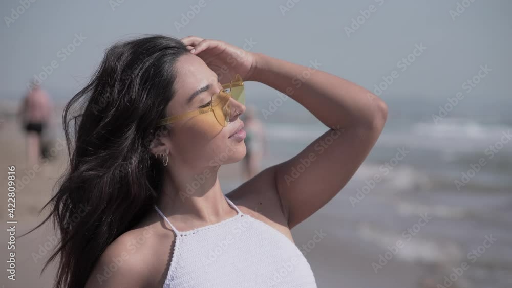 Brunette Lady In White Top Wearing Fancy Eyeglasses During Summer In Malvarrosa, Valencia Beach, Spain. - Medium Shot Brunette Lady In White Top Wearing Fancy Eyeglasses During Summer In Malvarrosa, Valencia Beach, Spain. - Medium Shot