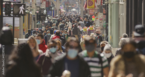 Anonymous crowd of people walking street wearing masks during Covid 19 pandemic in New York City photo
