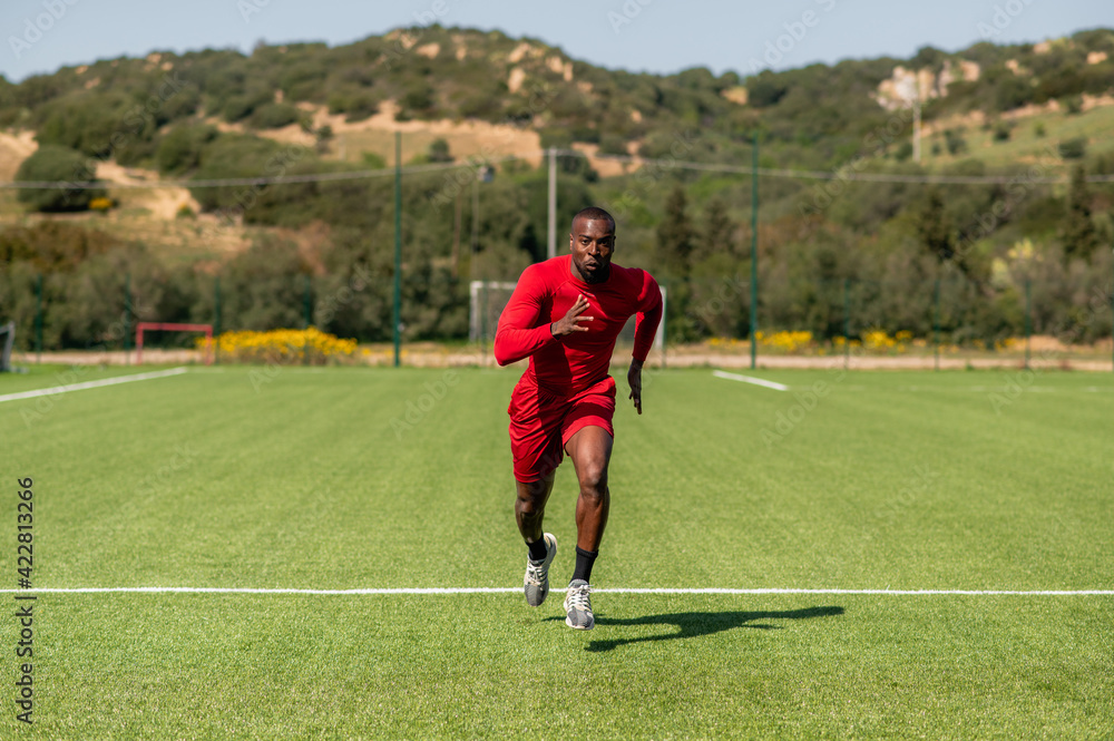 Black sportive speed runner, running in a football field.