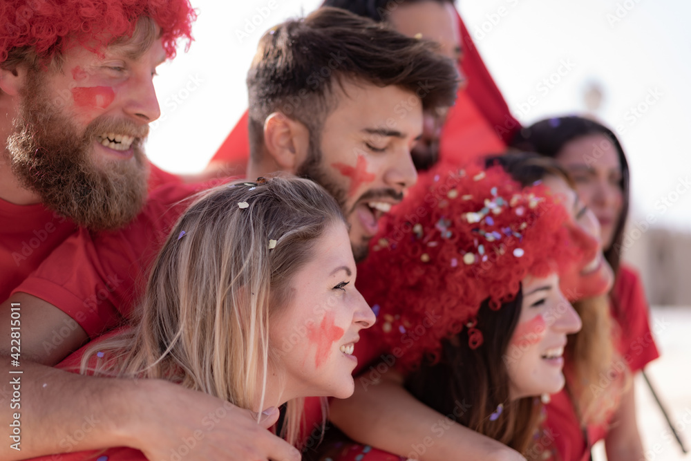 Football fan screaming, with red shirts inside of the stadium . Group of young people very excited about football. Sport and fun concept Football fan screaming, with red shirts inside of the stadium . Group of young people very excited about football. Sport and fun concept