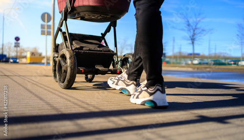 mom walks on the street with a baby in a stroller, stroller close-up, bottom view © rossiaa33