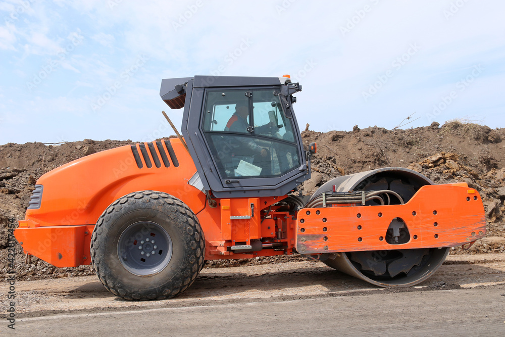 A modern road roller is building a new asphalt road A modern road roller is building a new asphalt road