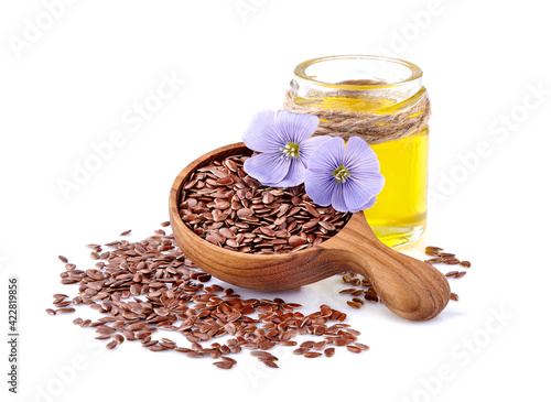 Fotografía Flax seeds in wooden spoon with flowers and oil on white background