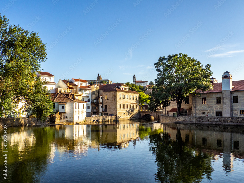 Old buildings in Viseu reflected on a Pavia river, Portugal - obrazy, fototapety, plakaty 