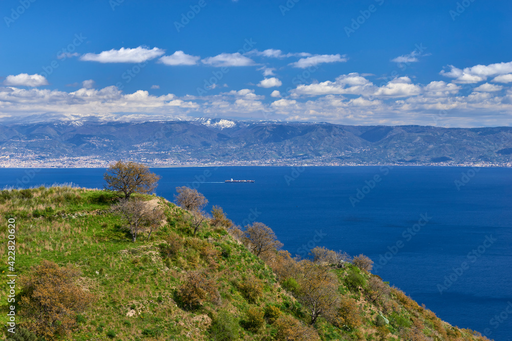 panoramic view of the Messina strait in a particular spring day with blue sky and limpid coast of Calabria with splashes of snow on the hills