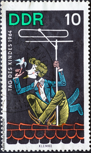 GERMANY, DDR - CIRCA 1964 : a postage stamp from Germany, GDR showing Children's picture master needle eye at the TV antenna. From the children's programs of the German television station