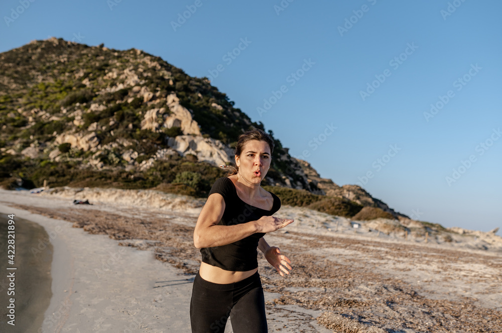 young sportive woman running on the seashore. Outdoors sports. young sportive woman running on the seashore. Outdoors sports.