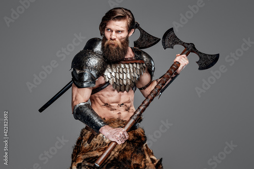 Proud viking with two axes and grimy face prepared to fight
