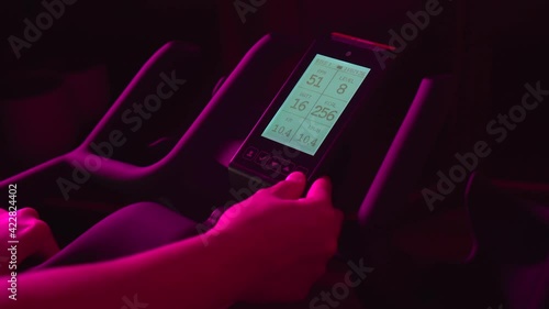 Young girl setting up bike display while doing night spinning session at home or gym