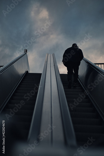 Mann auf Rolltreppe nach oben 