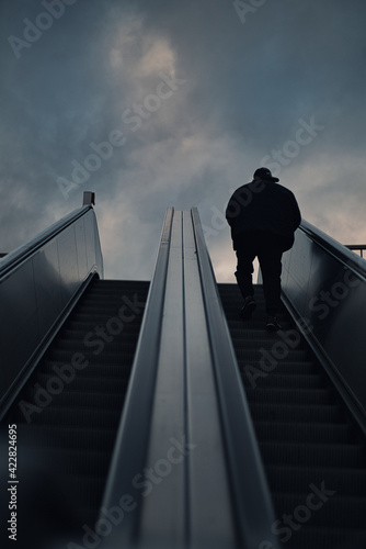 Mann auf Rolltreppe nach oben 