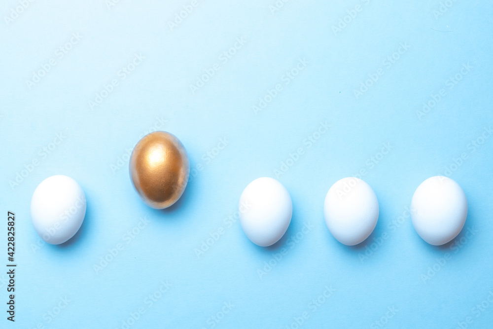 Easter holiday. Golden, white colour egg on pastel blue background in Happy Easter decoration. Spring holiday top view with copy space. Easter holiday. Golden, white colour egg on pastel blue background in Happy Easter decoration. Spring holiday top view with copy space.