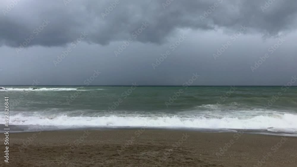 View of the sandy beach of the sea coast with moving waves. Cloudy day View of the sandy beach of the sea coast with moving waves. Cloudy day