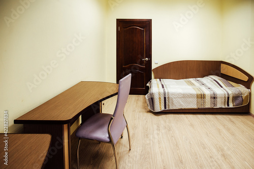 a room in a cheap hotel. minimalistic interior of an economy class hotel room. overnight stay for the traveler. several beds and a table