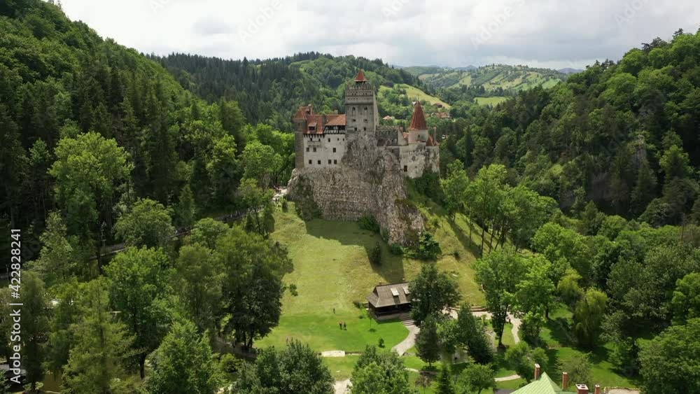 Bran, Romania, 29.07.2019. Dracula Bran Castle, medieval fortress in Transylvania near Brasov city. Drone lifts up, opens view on Romanian greenery, green mountains and hilltops on sunny summer day Bran, Romania, 29.07.2019. Dracula Bran Castle, medieval fortress in Transylvania near Brasov city. Drone lifts up, opens view on Romanian greenery, green mountains and hilltops on sunny summer day