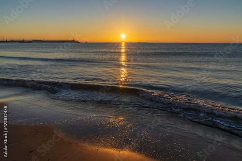 Beach and port of the town of Villajoyosa at sunrise.
