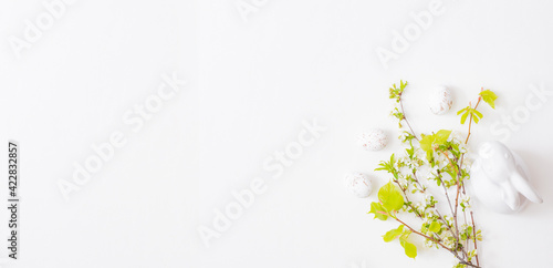 Flat lay easter composition with spring flowers and easter eggs on a white background