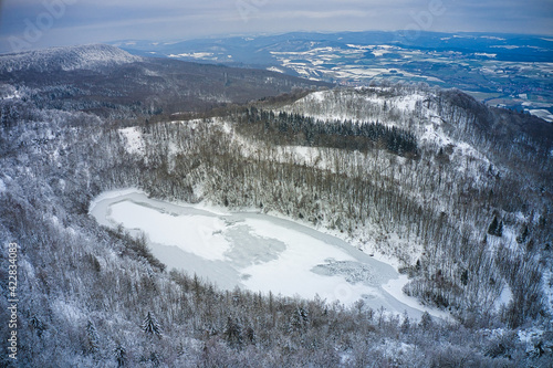 Luftaufnahme vom winterlichen und vereisten Bergsee auf dem Hohen Meißner