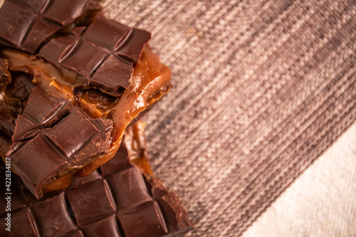 Broken assorted chocolate bar with caramel filling. Gluten free. Gourmet. Top view. Space for text.