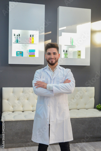 Foto Médico médico estético bienvenida hombre hombre brazos cruzados tienda producto