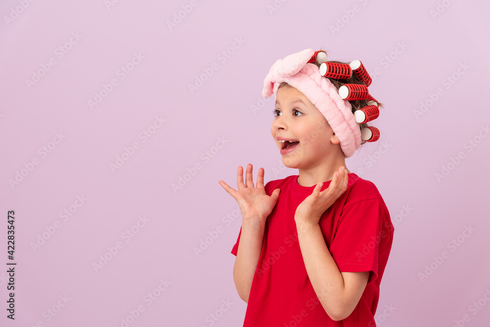 A little girl with curlers on her head is happy. A little girl with curlers on her head is happy.