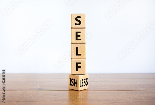 Selfish or selfless symbol. Turned cubes and changed the word 'selfish' to 'selfless'. Beautiful white background, copy space. Business, psuchological and selfish or selfless concept. photo