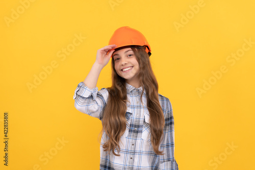 teen girl in helmet. builder kid in checkered shirt. building and construction concept.