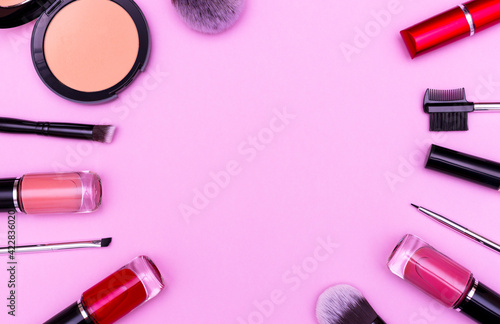 A set of professional makeup brushes and cosmetics on a pink background. The most necessary thing for a makeup artist.