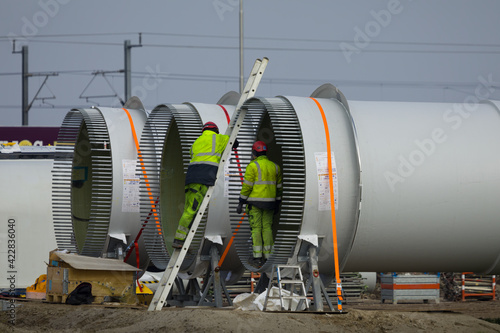 Construction workers preparing the rotor blades of a new wind turbine.