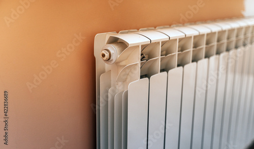 Close up of modern battery in room. White heating radiator indoor. photo