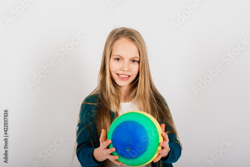 Beautiful girl holding coloured bright ball isolated on white