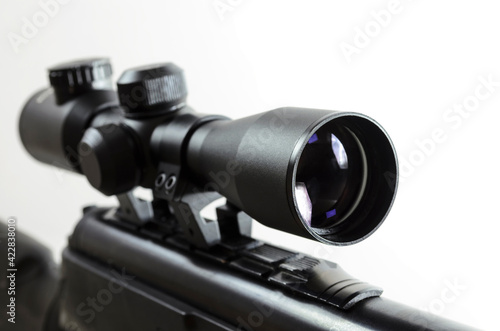 Air rifle with an optical sight on a light background