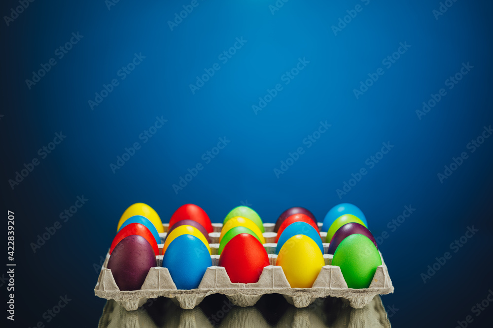 Easter festive multicolor eggs carton, blue background - obrazy, fototapety, plakaty 