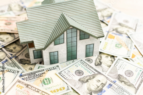 Obraz na plátne The model of the house costs on a pile of notes