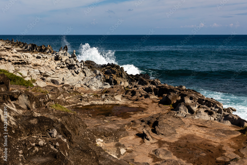 Vertical rocks on Makaluapuna Point, Maui, stand along the shore in a formation known as the dragon's teeth.
